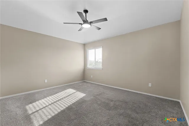 a view of a big room with windows and ceiling fan