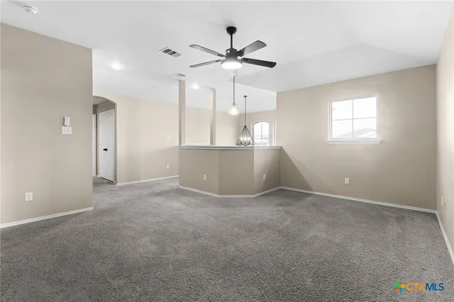 an empty room with fan and windows