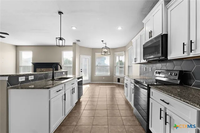 a kitchen with stainless steel appliances granite countertop a sink and a stove