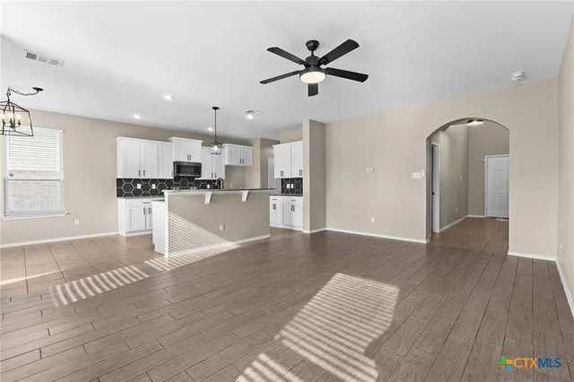a view of a kitchen with wooden floor and a ceiling fan