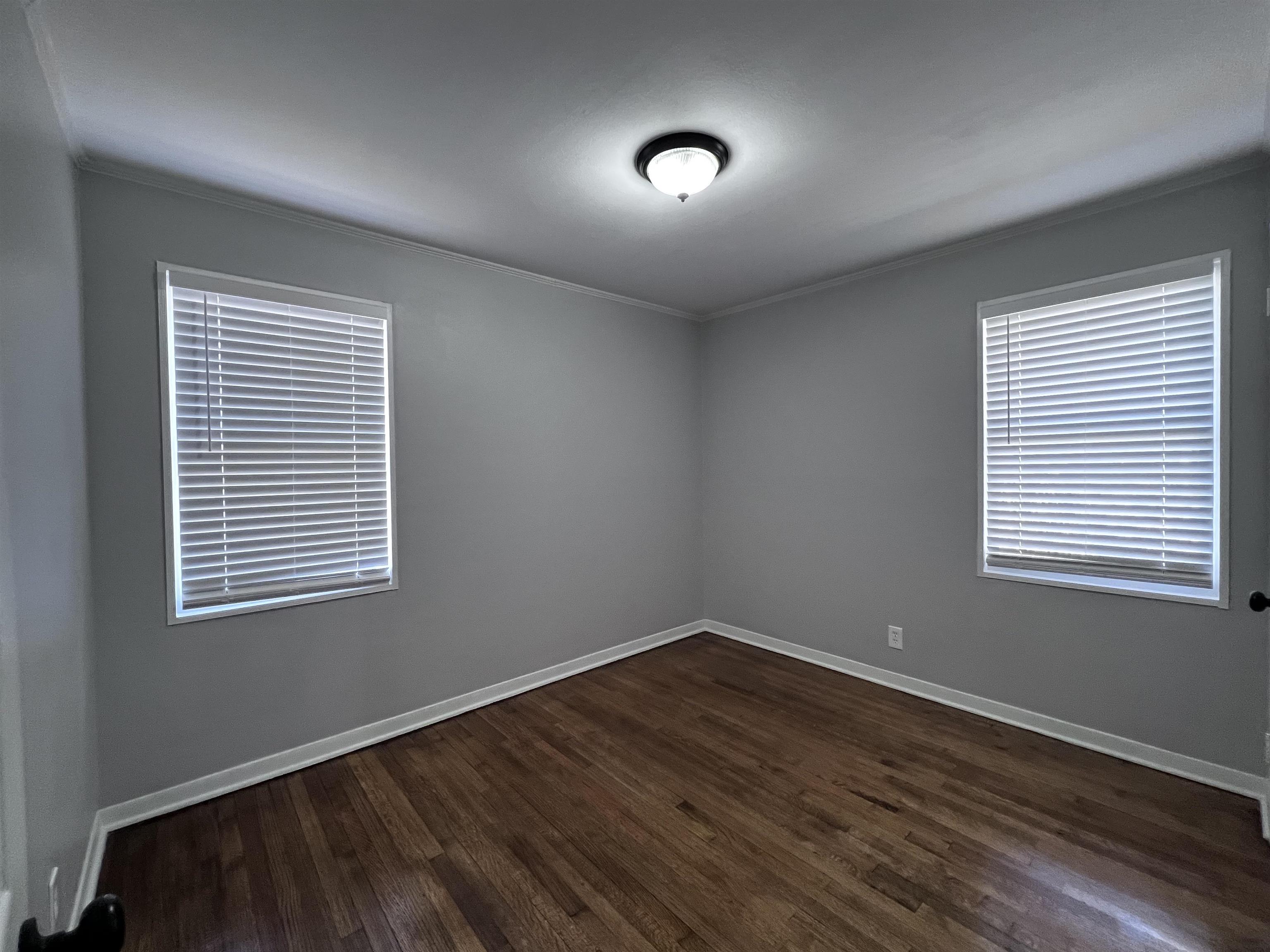 4914 Sea Isle Road Memphis, TN 38117 - Photo 13 of 23 a view of an empty room with wooden floor and a window