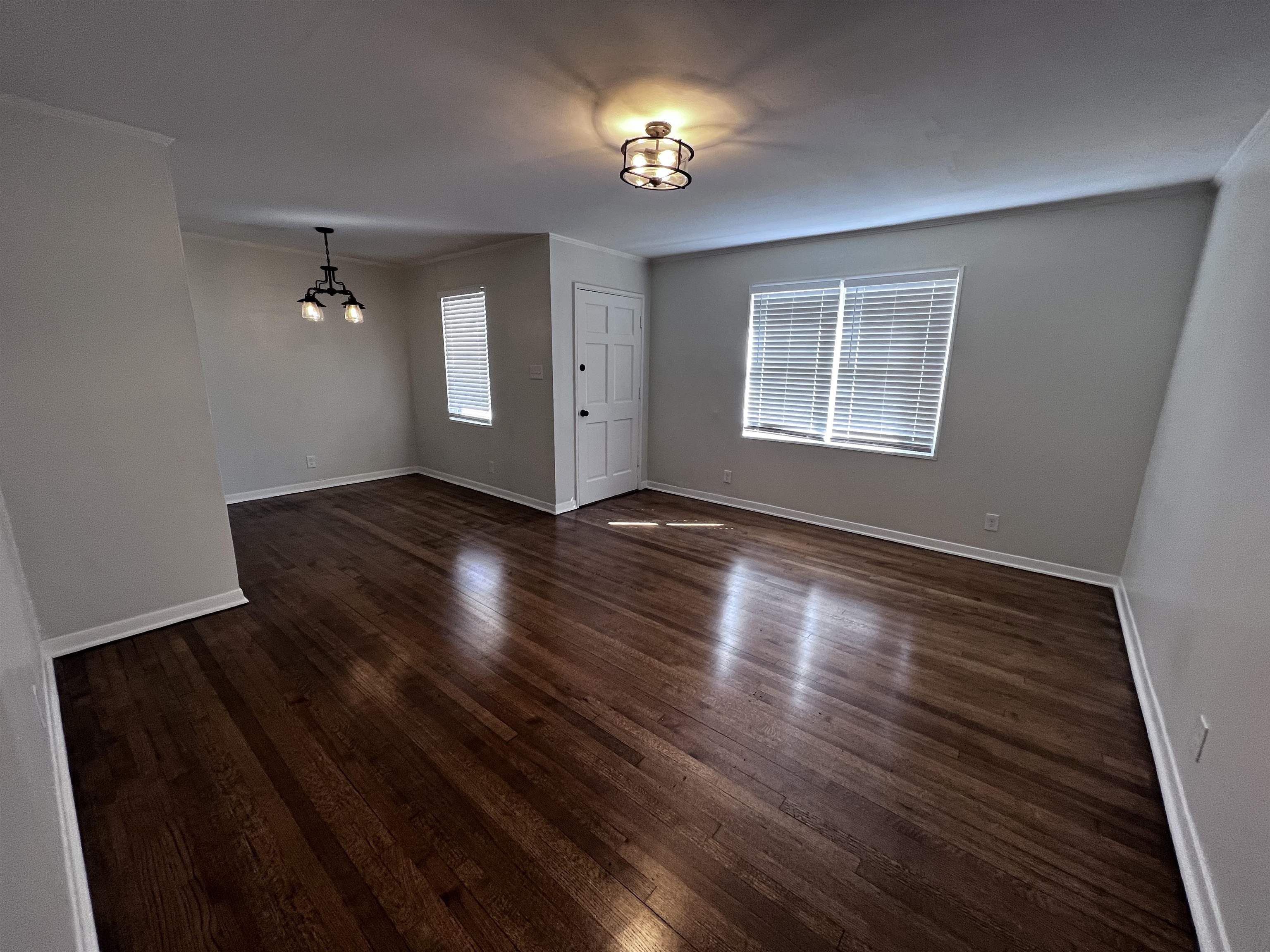 4914 Sea Isle Road Memphis, TN 38117 - Photo 4 of 23 a view of an empty room with wooden floor and a window