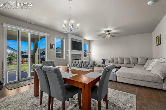 a view of a dining room with furniture a chandelier and wooden floor