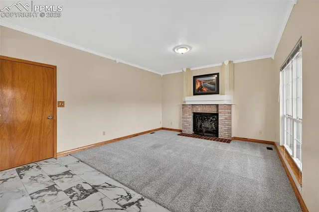 a view of a livingroom with a fireplace and a window