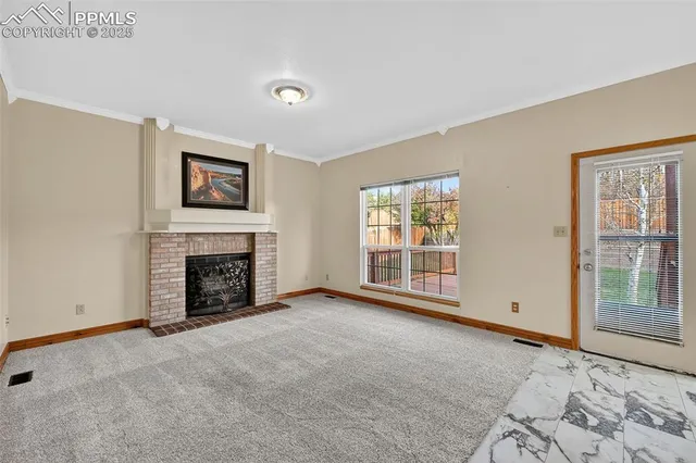 a view of an empty room with a fireplace and a window