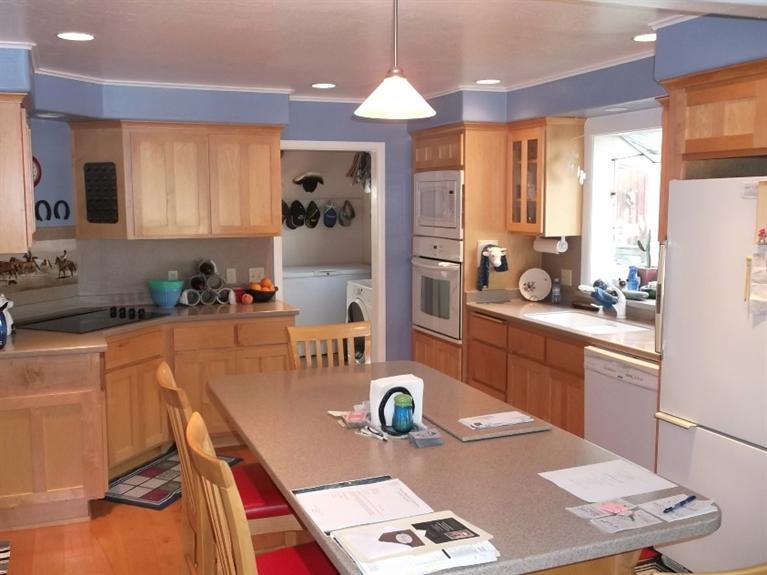 1604 Meridian Road Eagle Point, OR 97524 - Photo 23 of 26 a kitchen with stainless steel appliances granite countertop a stove a refrigerator a sink a dining table and chairs with wooden floor