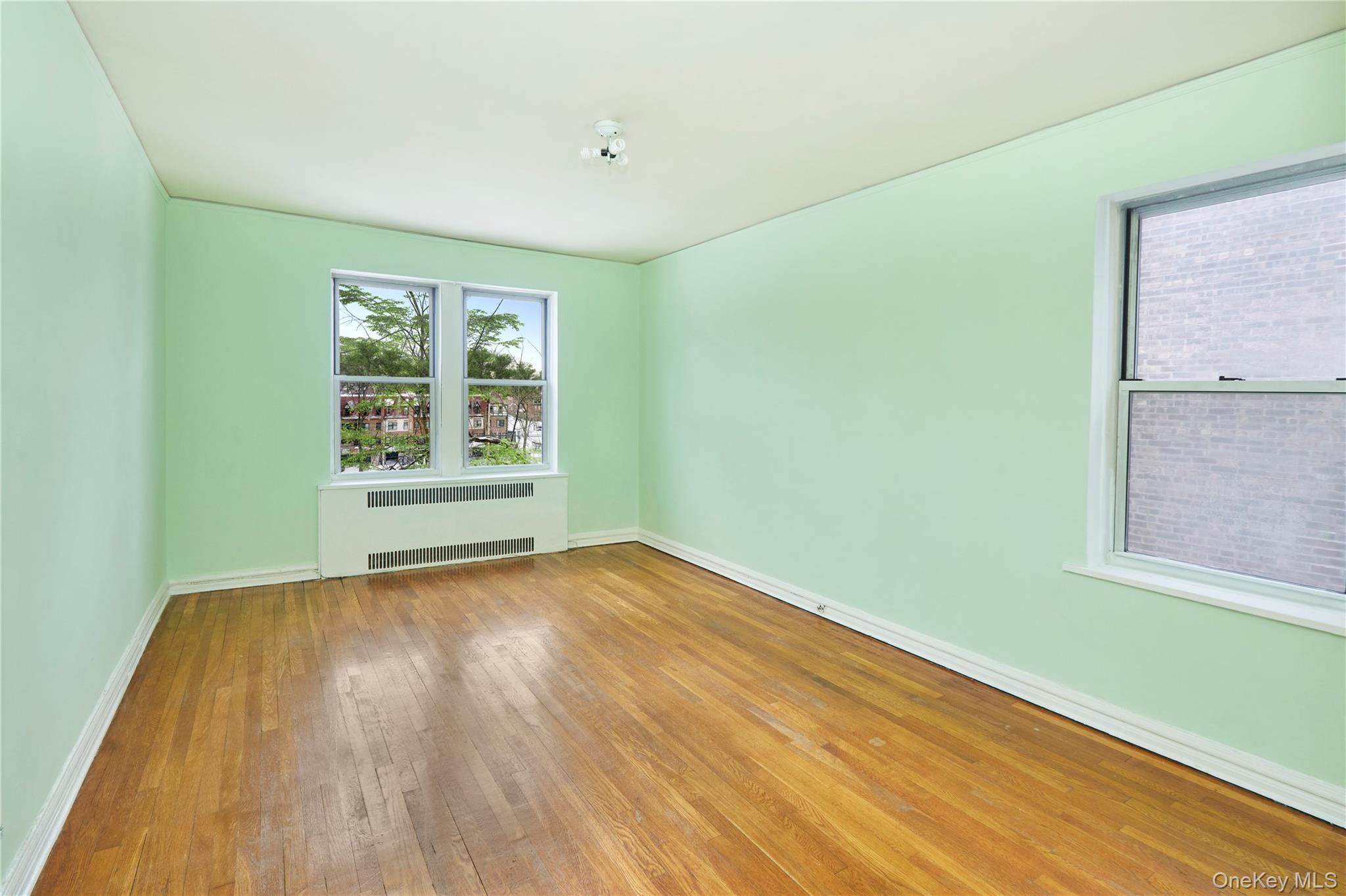 75-40 Austin Street, Unit 5 Queens, NY 11375 - Photo 1 of 12 an empty room with wooden floor and windows