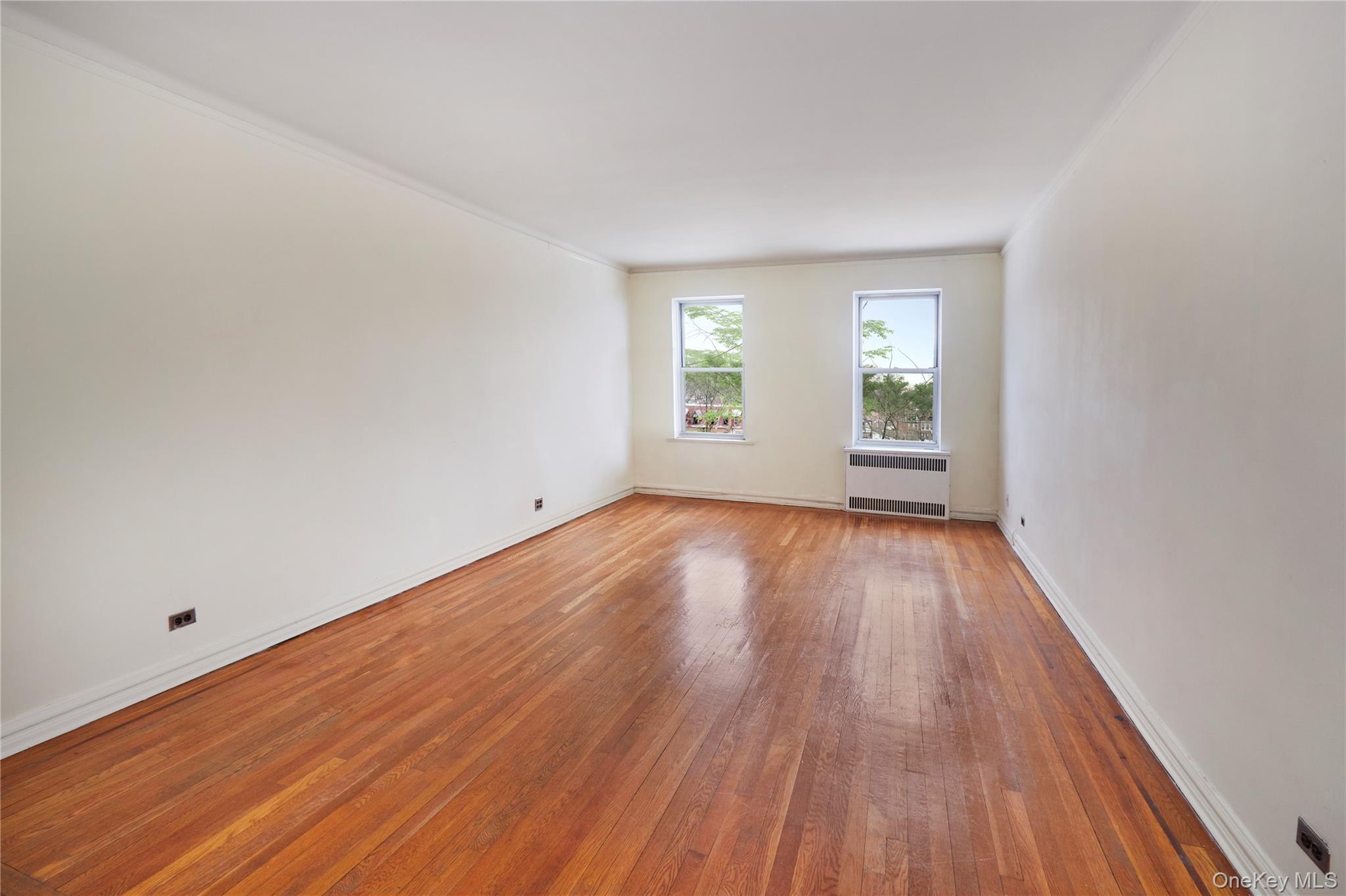 75-40 Austin Street, Unit 5 Queens, NY 11375 - Photo 3 of 12 a view of empty room with wooden floor and fan