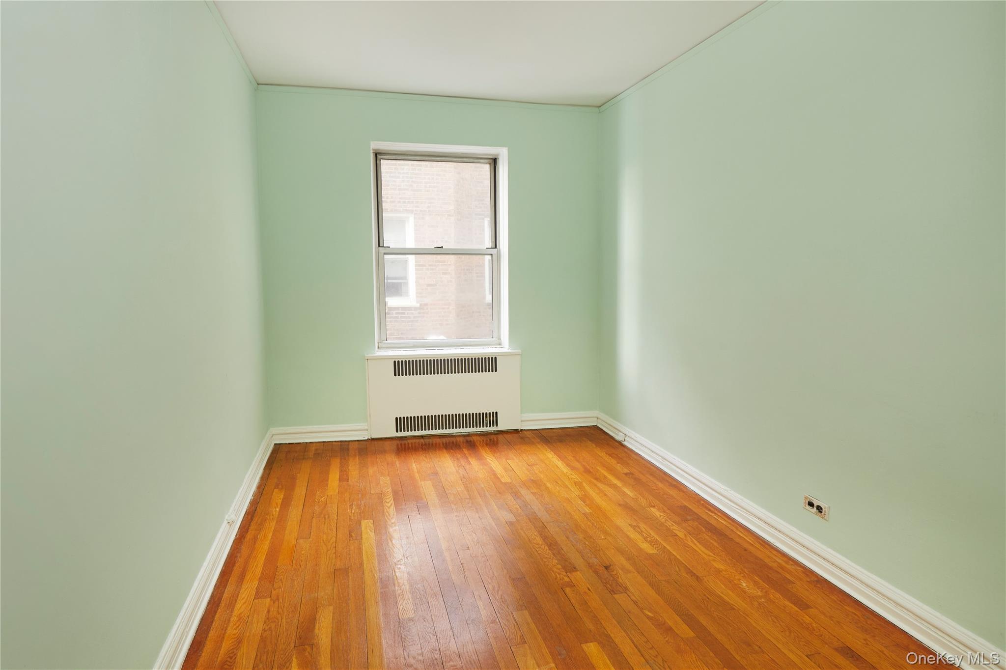 75-40 Austin Street, Unit 5 Queens, NY 11375 - Photo 6 of 12 an empty room with wooden floor and windows