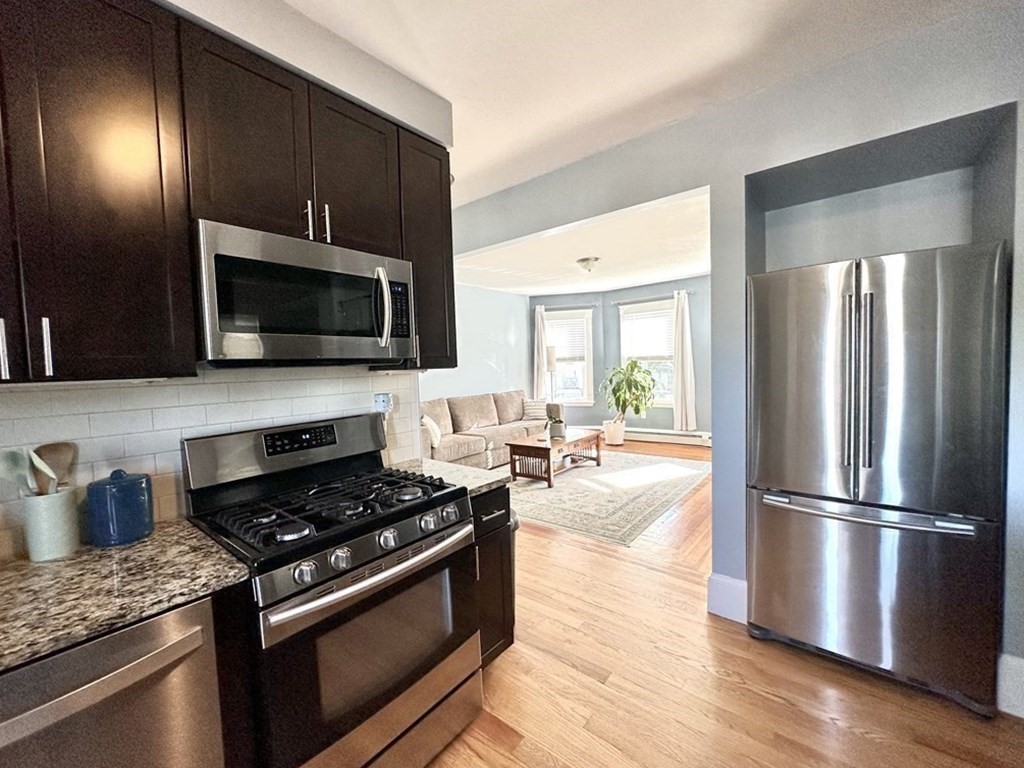 153 Rowe Street, Unit 1 Boston, MA 02131 - Photo 4 of 11 a kitchen with a stove a microwave and refrigerator