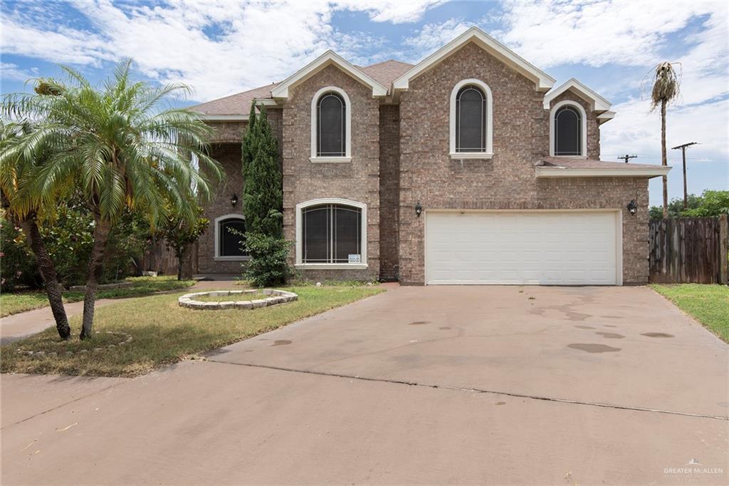 2001 Quail Lane Mission, TX 78572 - Photo 1 of 28 Brick exterior featuring arched windows, a two-car garage, and mature palm trees