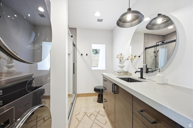 1833 Pine Loop Road Coalville, UT 84017 - Photo 13 of 26 Bathroom featuring a floating wood-finish vanity with a light-toned countertop, a rectangular undermount sink, and a black wall-mounted faucet