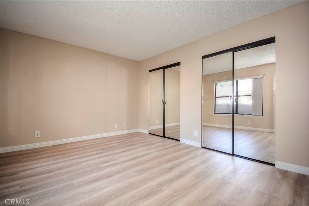 10655 Lemon Avenue, Unit 1001 Rancho Cucamonga, CA 91737 - Photo 14 of 22 a view of an empty room with window and wooden floor