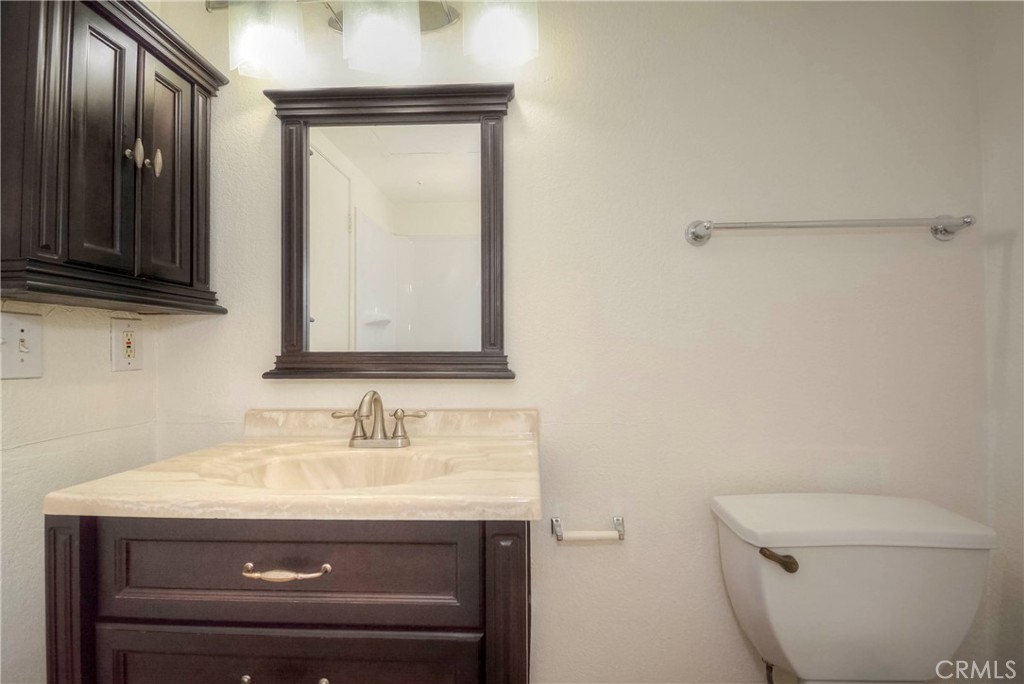 10655 Lemon Avenue, Unit 1001 Rancho Cucamonga, CA 91737 - Photo 19 of 22 a bathroom with a granite countertop toilet sink and mirror