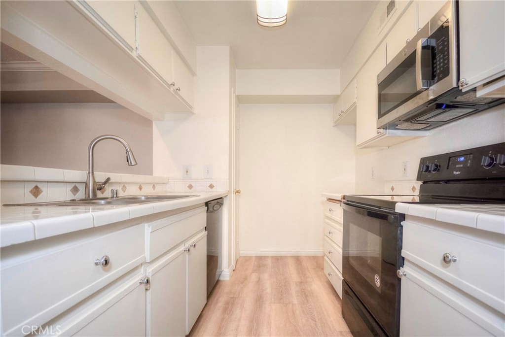 10655 Lemon Avenue, Unit 1001 Rancho Cucamonga, CA 91737 - Photo 7 of 22 a kitchen with granite countertop a sink stainless steel appliances and cabinets