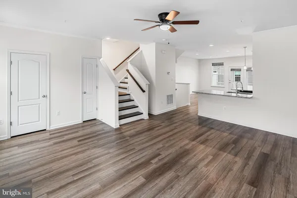 a view of empty room with wooden floor and ceiling fan