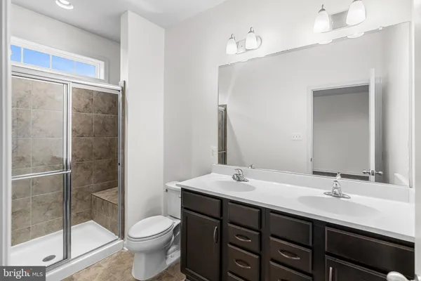 a bathroom with a double vanity sink toilet and a mirror