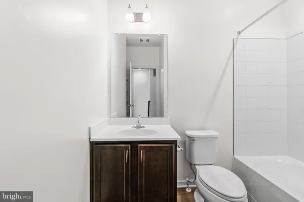 a bathroom with a sink a toilet a mirror and shower