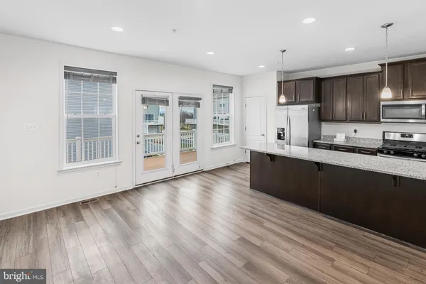 a large kitchen with stainless steel appliances wooden floors and wooden cabinets