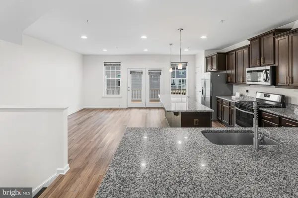 a large kitchen with stainless steel appliances granite countertop a sink stove and refrigerator