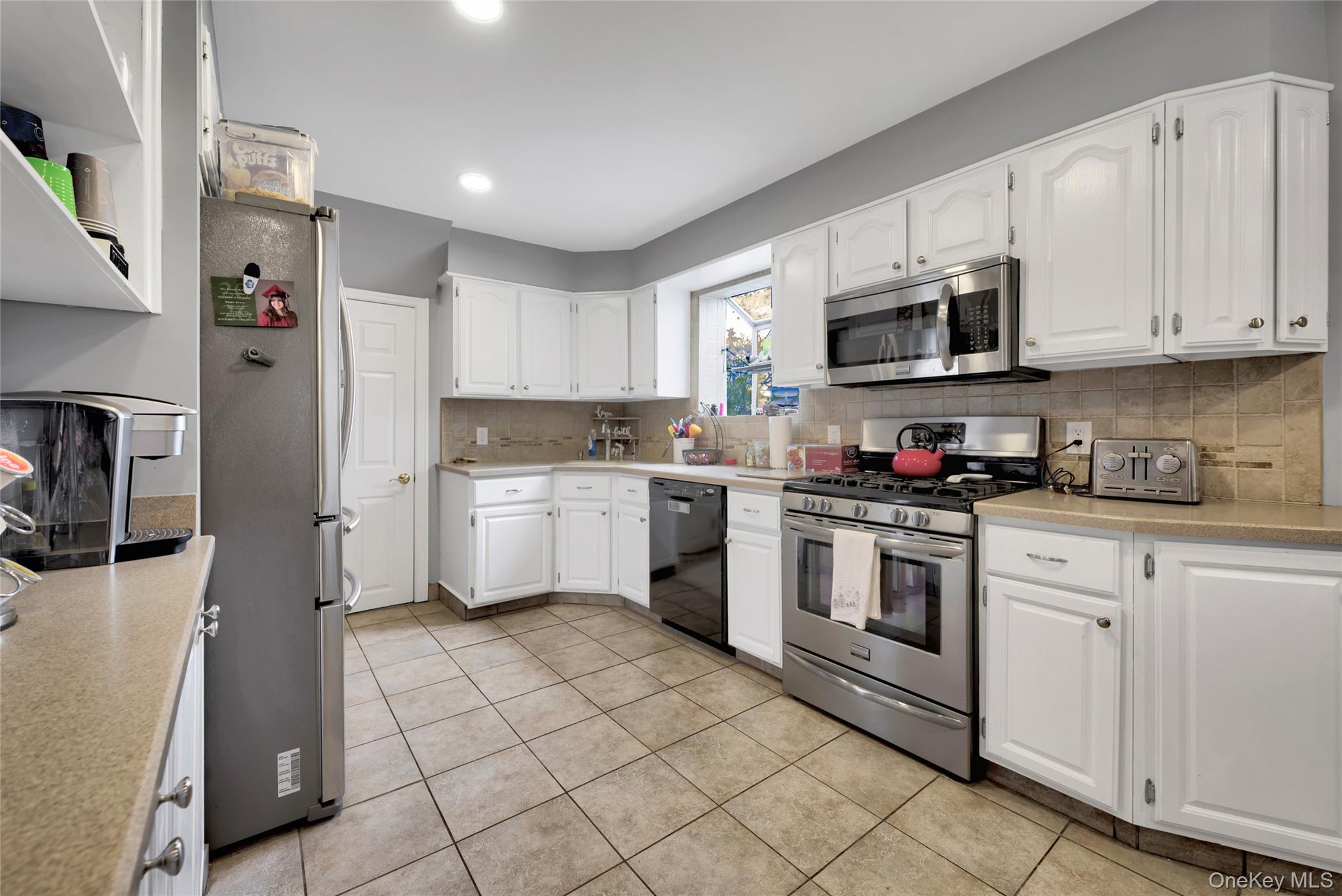 5 Argyle Road Merrick, NY 11566 - Photo 7 of 31 a kitchen with white cabinets stainless steel appliances and sink