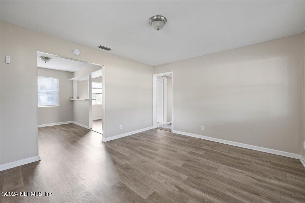 6584 Aires Road Jacksonville, FL 32244 - Photo 5 of 27 a view of an empty room with wooden floor and a window