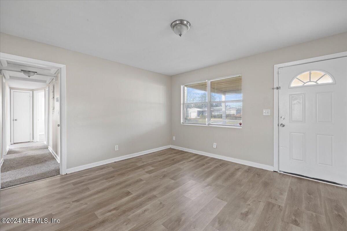 6584 Aires Road Jacksonville, FL 32244 - Photo 6 of 27 a view of empty room with wooden floor and fan