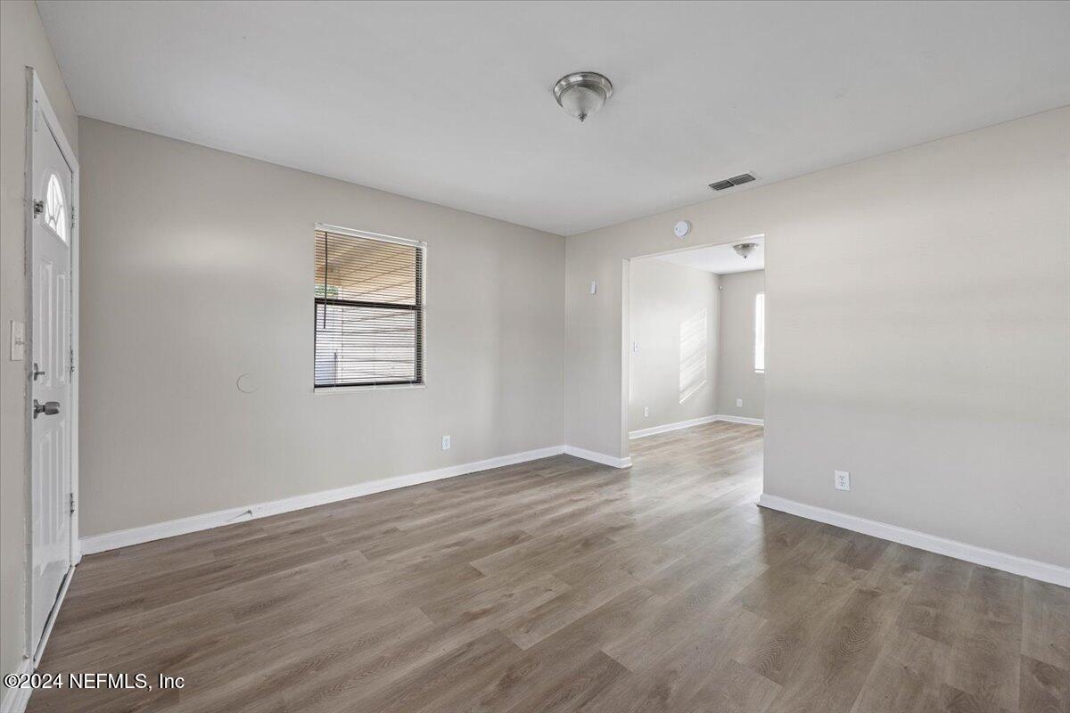 6584 Aires Road Jacksonville, FL 32244 - Photo 8 of 27 an empty room with wooden floor and windows
