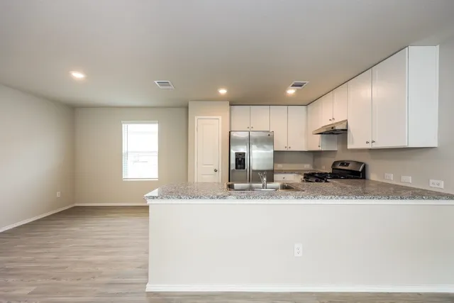 a kitchen with a refrigerator sink and cabinets