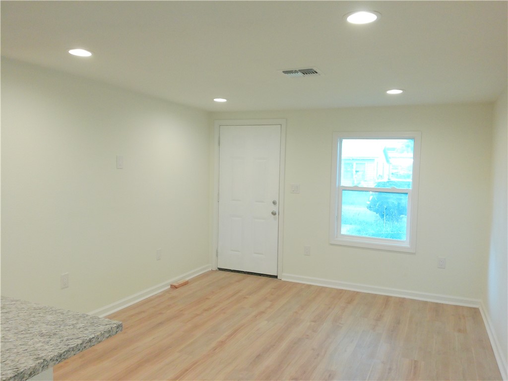 306 Allison Drive Gregory, TX 78359 - Photo 3 of 15 an empty room with wooden floor and windows