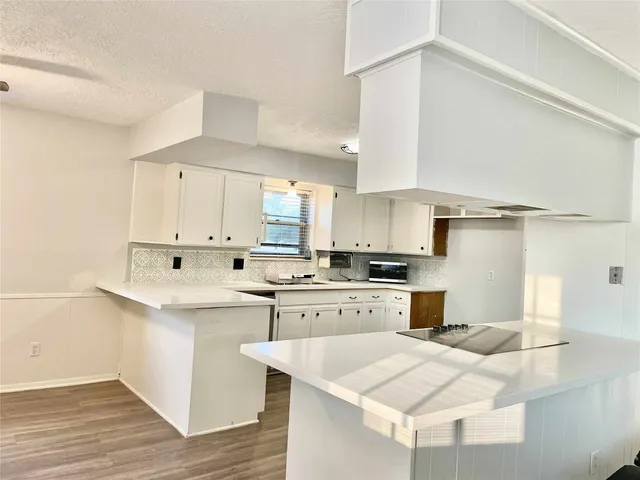a kitchen with a sink a stove and cabinets