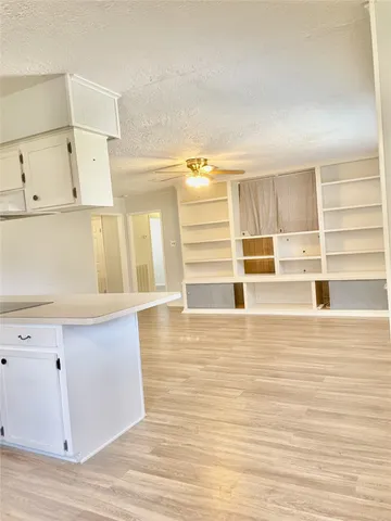 a view of a kitchen with wooden floor and electronic appliances