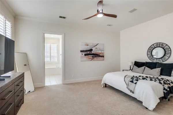 a bedroom with a bed and a flat tv screen on dresser
