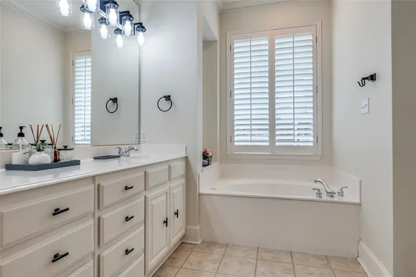 a bathroom with a tub a sink and mirror