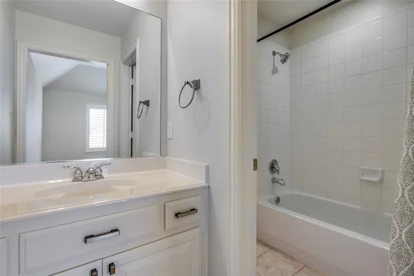 a bathroom with a tub sink shower and mirror