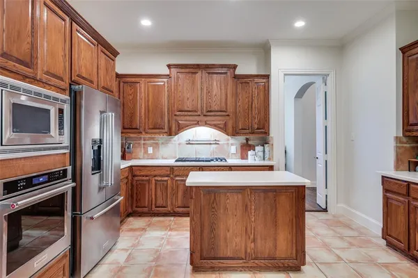 a kitchen with stainless steel appliances granite countertop a stove refrigerator and cabinets