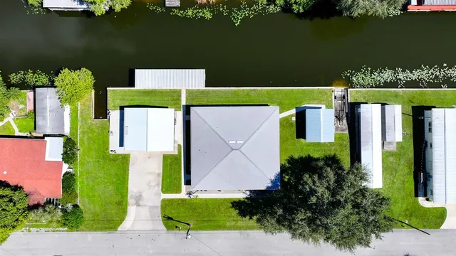 an aerial view of a house with a garden and lake view