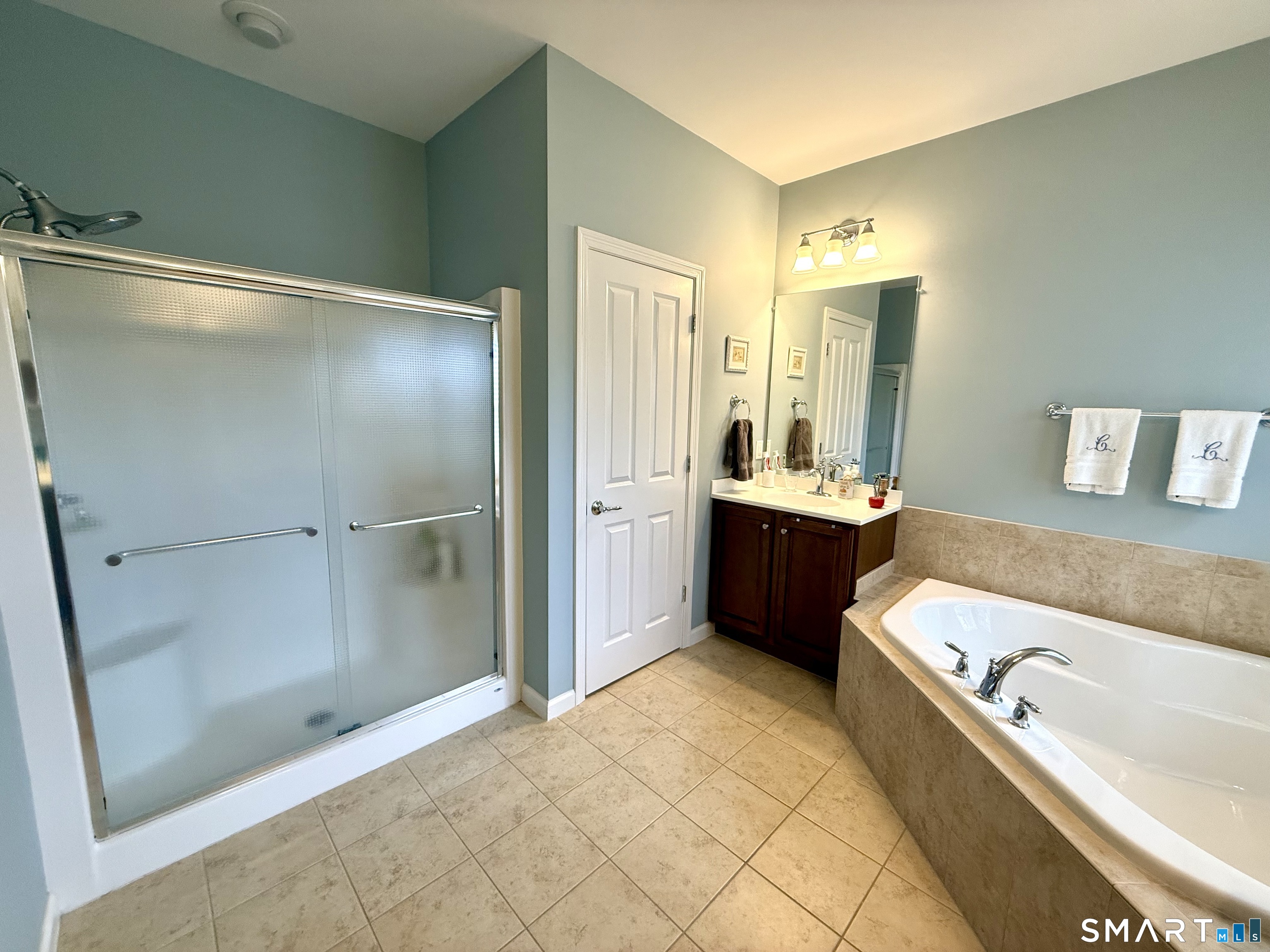 575 Inverness Court, Unit 575 Oxford, CT 06478 - Photo 21 of 37 a bathroom with a tub a sink and a large mirror