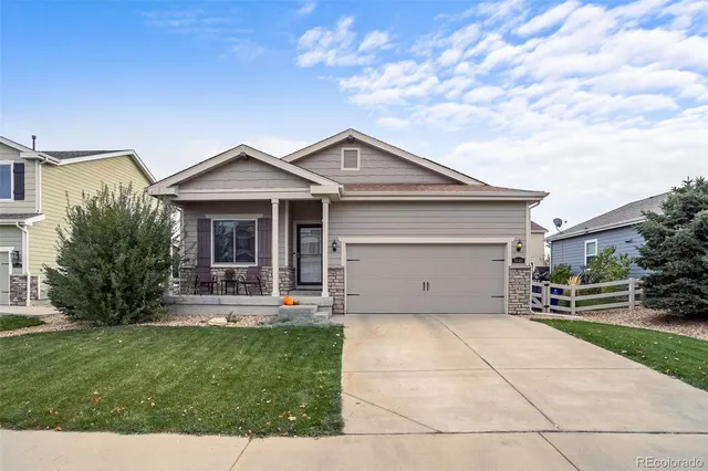 a front view of a house with a garden and yard