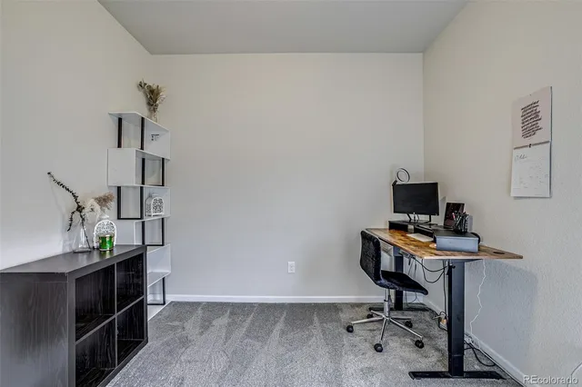 a view of a workspace with furniture and a window