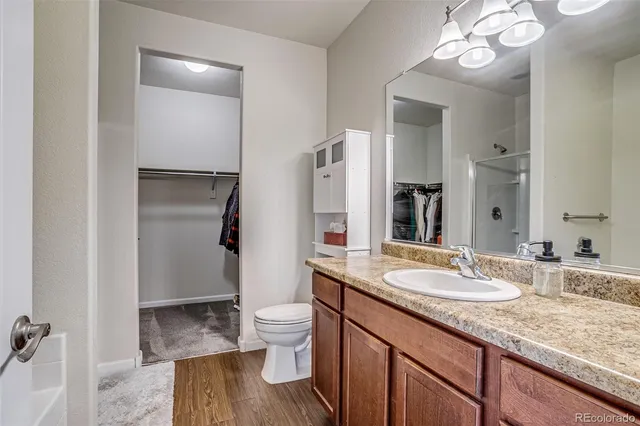 a bathroom with a granite countertop sink toilet and shower