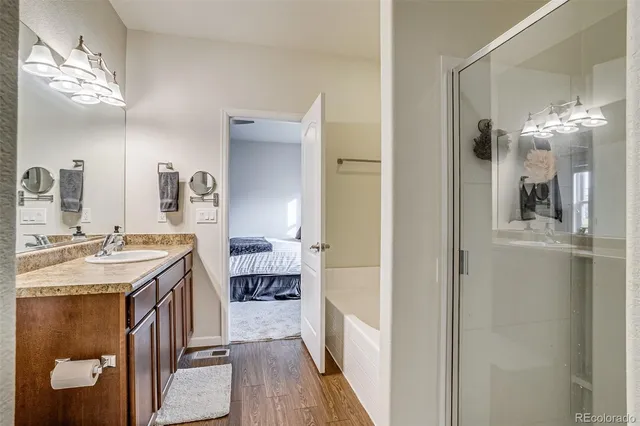 a en suite bathroom with a granite countertop sink a mirror and shower