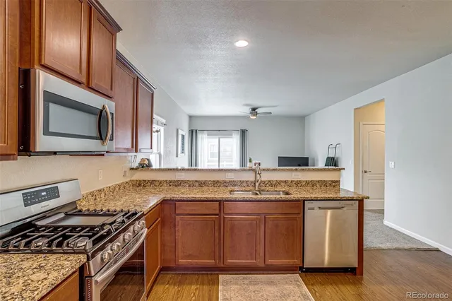 a kitchen with granite countertop a sink stove and cabinets