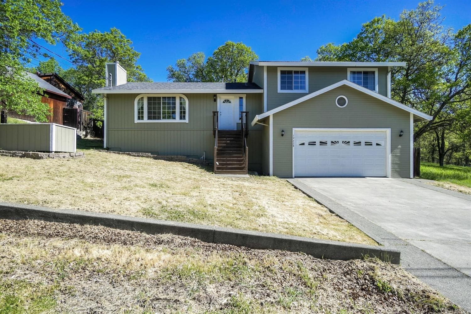 19228 Moon Ridge Road Hidden Valley Lake, CA 95467 - Photo 1 of 1 a front view of a house with a yard