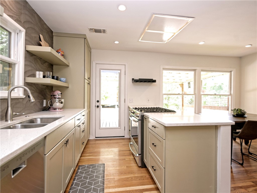 5707 Avenue F Austin, TX 78752 - Photo 5 of 17 a kitchen with stainless steel appliances granite countertop a sink stove and cabinets