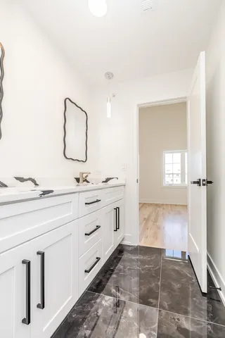 a spacious bathroom with a double vanity sink and mirror