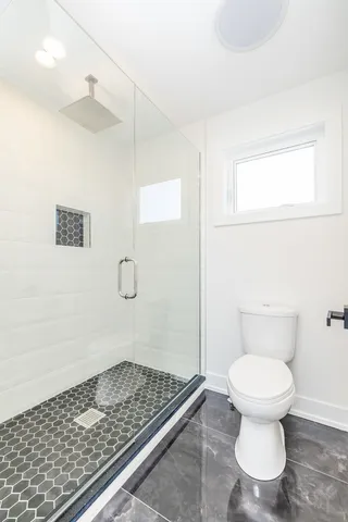 a bathroom with a toilet and a shower