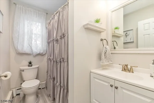 a bathroom with a sink a toilet and shower curtain