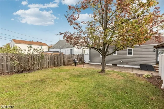 a view of a large garden with large tree and wooden fence