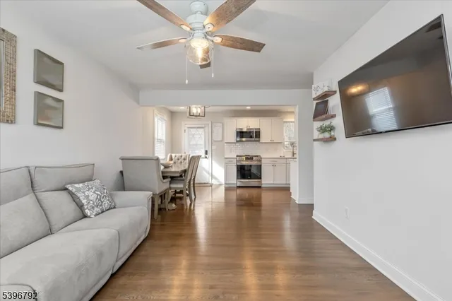 a living room with furniture kitchen view and a flat screen tv